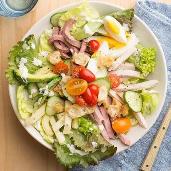 Grace Deli's Cobb salad with lettuce, meats, egg, avocado, tomatoes, and croutons.